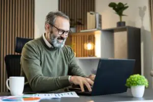 remote employee sending a fax through a cloud fax platform from a home office laptop
