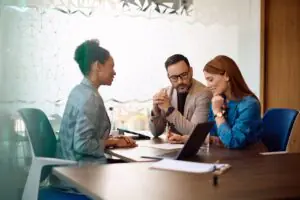 Bank manager reviewing regulated documents with clients, a common regulated industry fax workflow