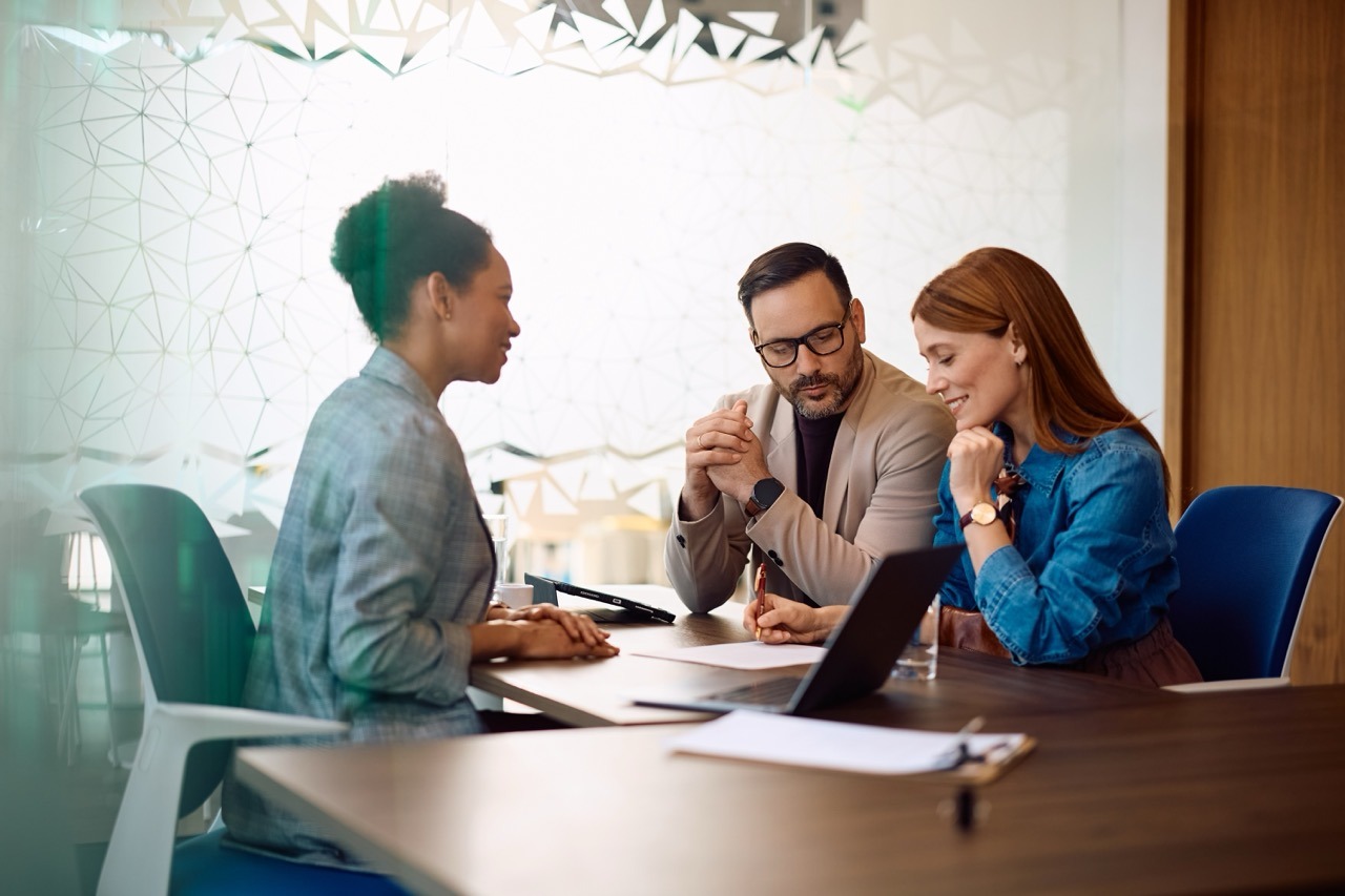 Bank manager reviewing regulated documents with clients, a common regulated industry fax workflow