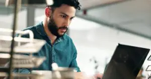 IT professional reviewing fax infrastructure risk management settings on a laptop