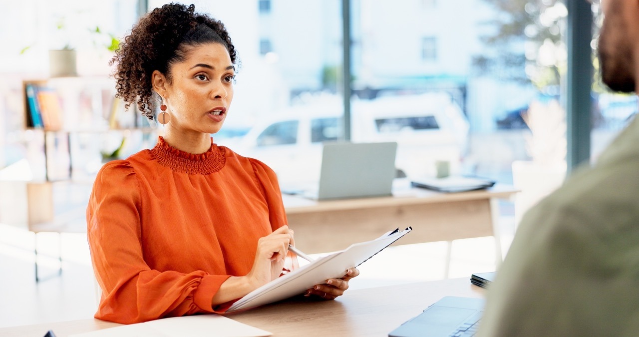 HR manager reviewing a confidential employee document during an onboarding meeting